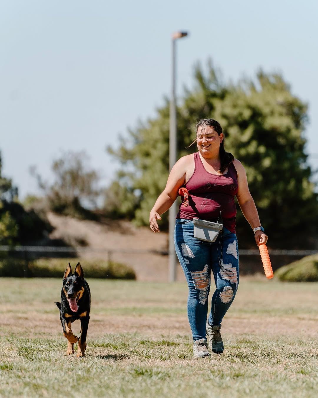 Bri walking through a park with Lemon heeling at her side